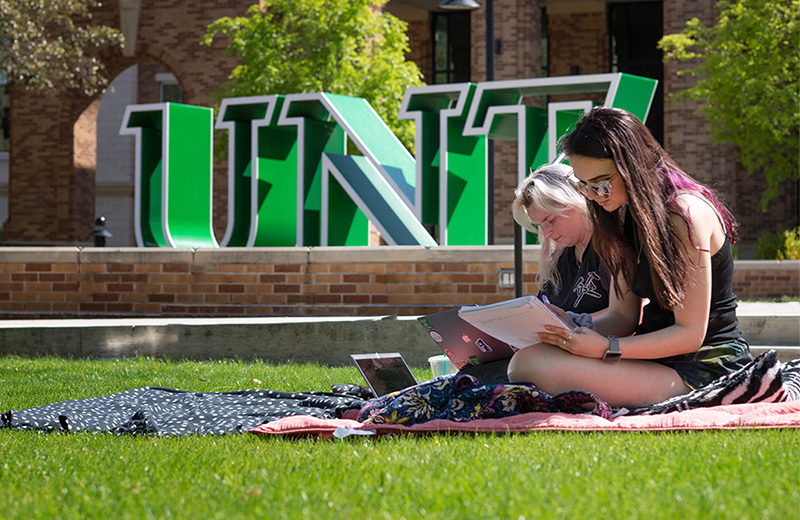 Students studying in front of the UNT Welcome Center. 