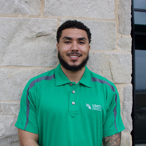 Man wearing a green collared shirt, smiling