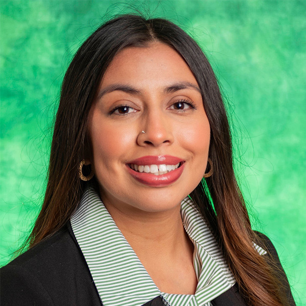 Woman smiling in front of a green background